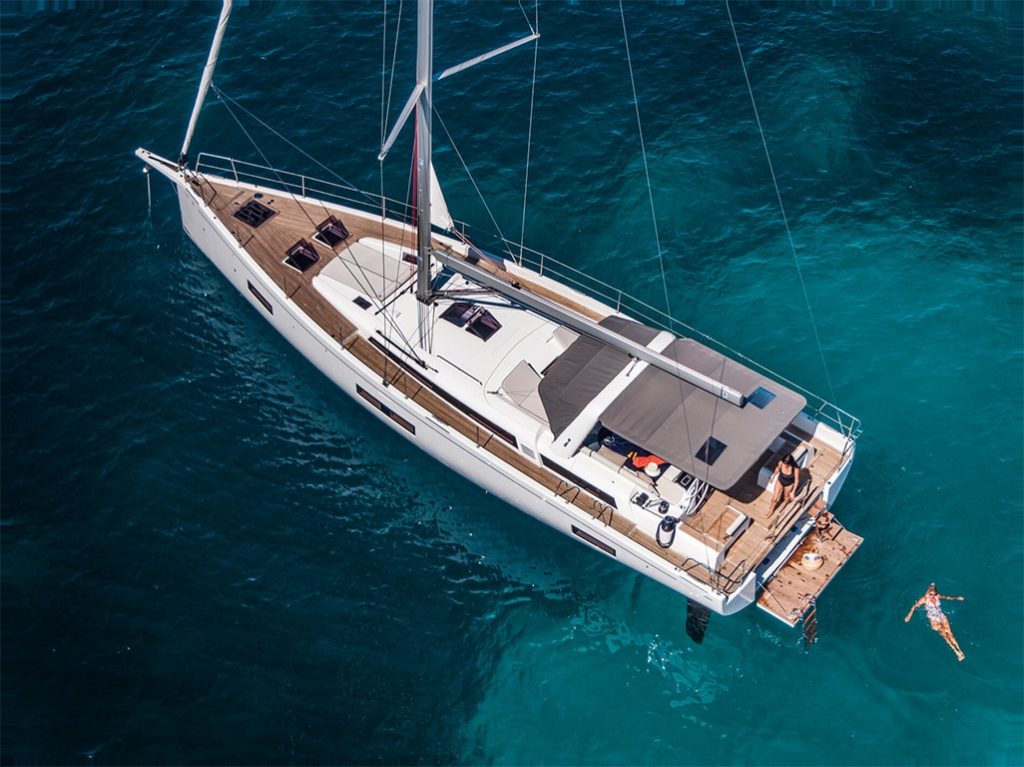 A person swims in the water on the Beneteau Oceanis 54.