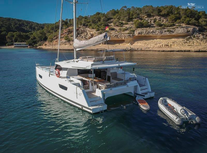A Fountaine Pajot Saona 47 yacht is moored in the water. In terms of yacht charter, it offers unparalleled luxury and comfort. With her excellent handling at sea, she offers a unique charter experience.